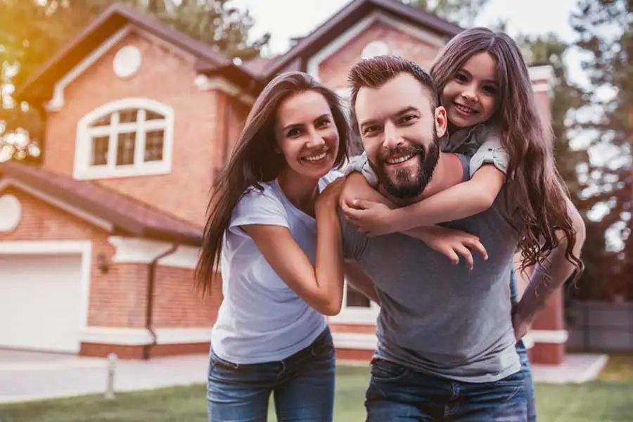 Family standing in front yard smiling - Protect your families home from termite damage with SOS Exterminating Phoenix Metro & Northern Arizona